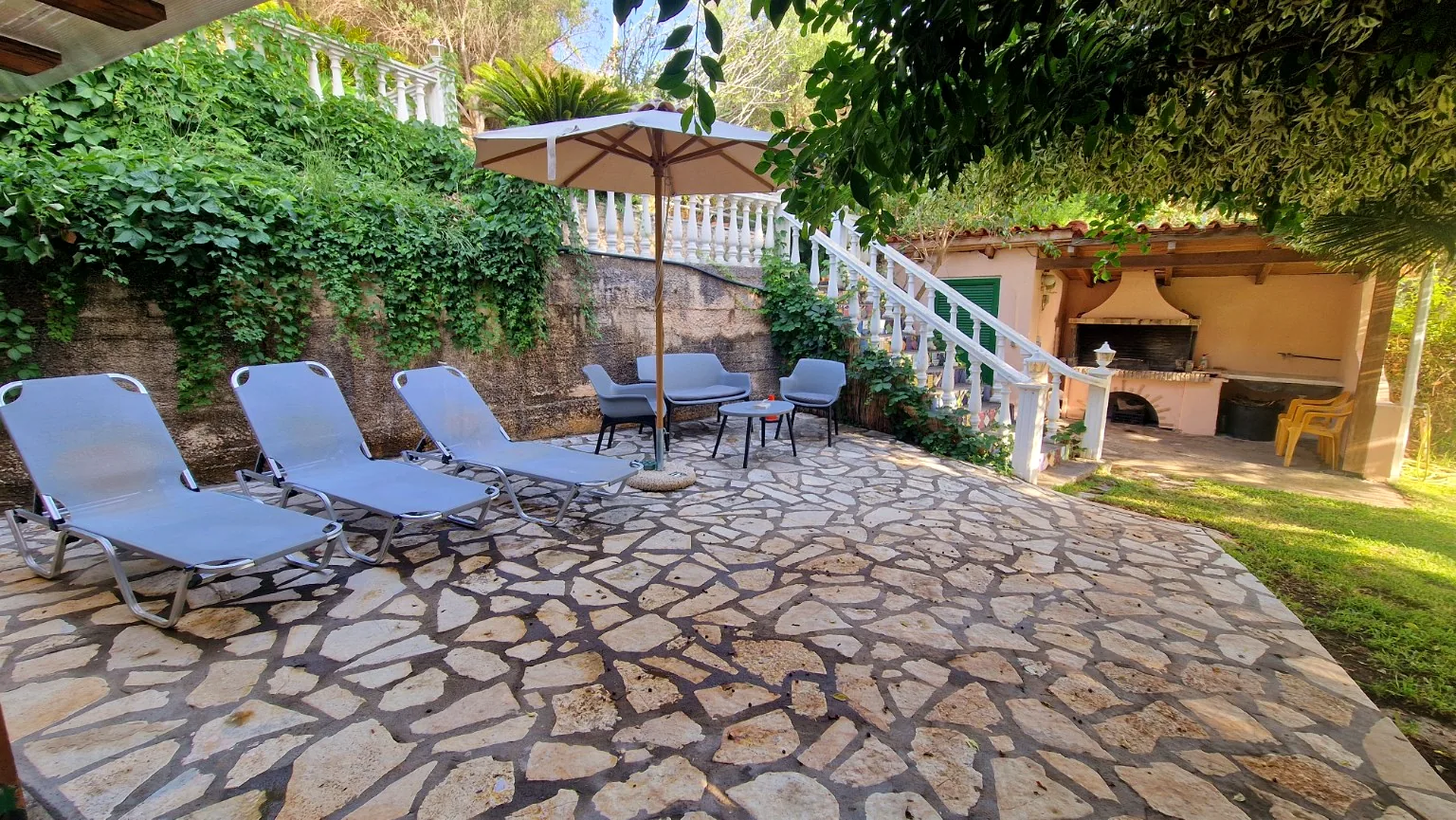 Outdoor terrace with sun loungers and barbecue area at Il Prato, Villa Vanda